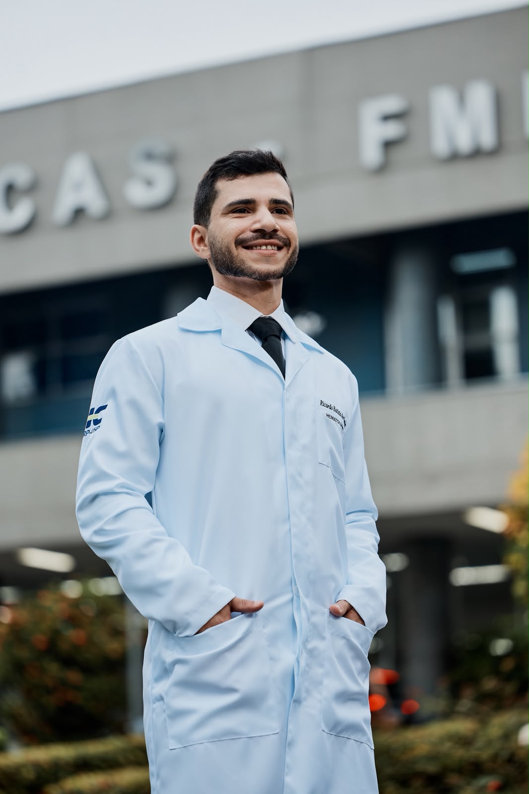 Dr. Ricardo Batista de jaleco em frente ao Hospital das Clínicas da FMRP-USP, em Ribeirão Preto.